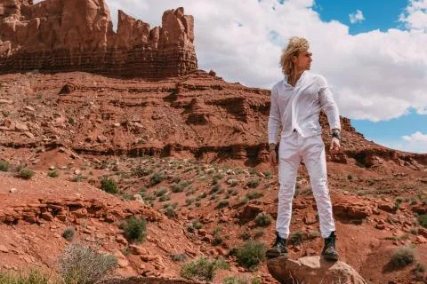 A curly haired blonde man posing around the famous Buttes of Monument Valley  Stock Photos