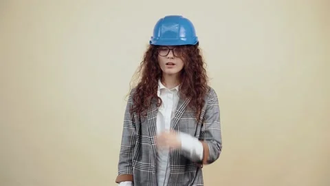 The curly-haired engineer puts her helmet on her head, posing in fashion, she Stock Footage 150898132