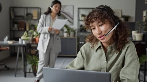 Curly-Haired Girl with Headset Working in Customer Support Call Center Stock Footage 343617995