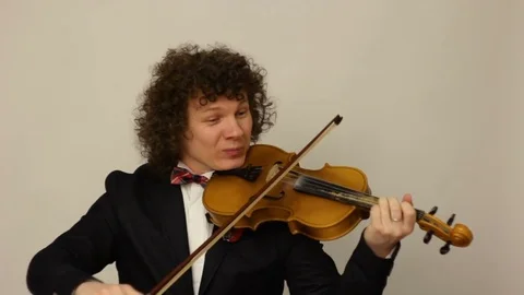 Curly-haired guy playing the violin Stock Footage 74249657