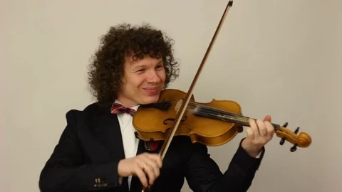 Curly-haired guy playing the violin Stock Footage 74249919