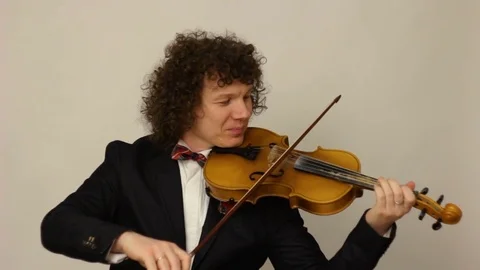 Curly-haired guy playing the violin Stock Footage 74250111