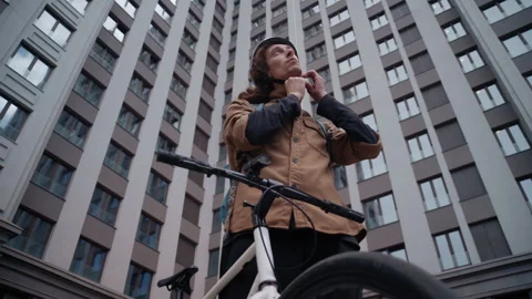 Curly Haired Guy Putting Helmet Beside Bike Downtown Stockbeeldmateriaal 317561902