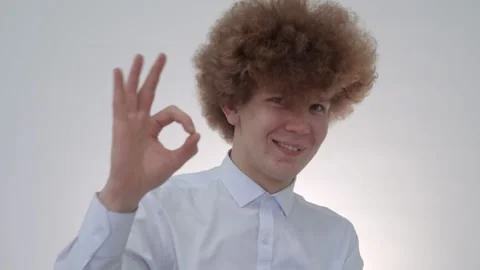 Curly-haired guy shows the OKAY sign with his fingers Stock Footage 146576340