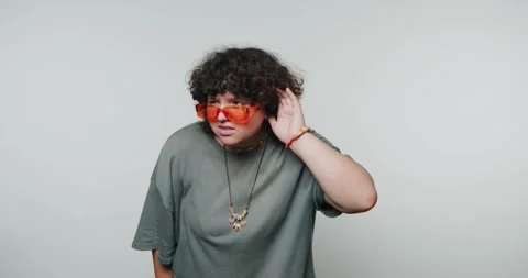 Curly-haired individual with sunglasses listens intently during a creative .. Stock Footage 316182653