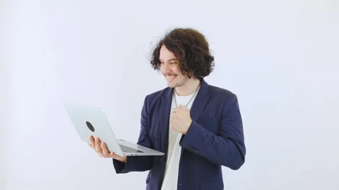 Curly-haired programmer in a blazer is typing on a laptop Stock Footage 297224160
