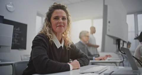 Curly Haired Woman Attends Coding Workshop, Looking at Screen, Smiling Warmly Stock Footage 321251928
