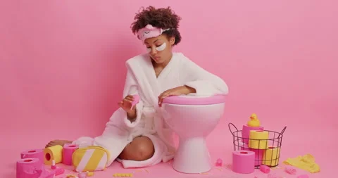 Curly haired woman looks attentively on silicone menstruation cup finds better Stock Footage