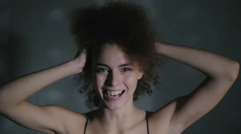 The curly-headed girl cheerfully laughs and dances Stock Footage 59238683