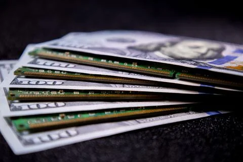 Currency and computer chips placed together on a black surface showing their Stock Photos