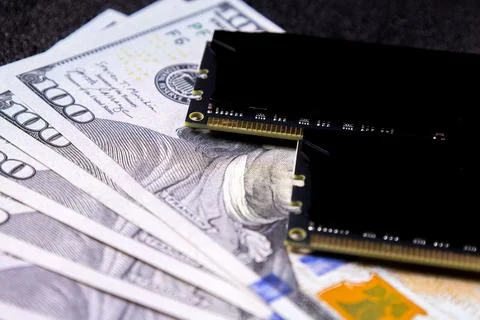 Currency and computer hardware are shown together on a dark surface, Stock Photos