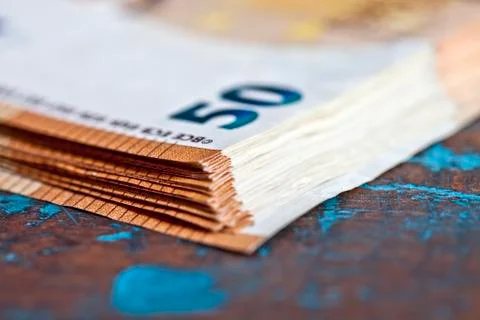 Currency bank notes stacked on rustic wooden table background closeup. Stock Photos