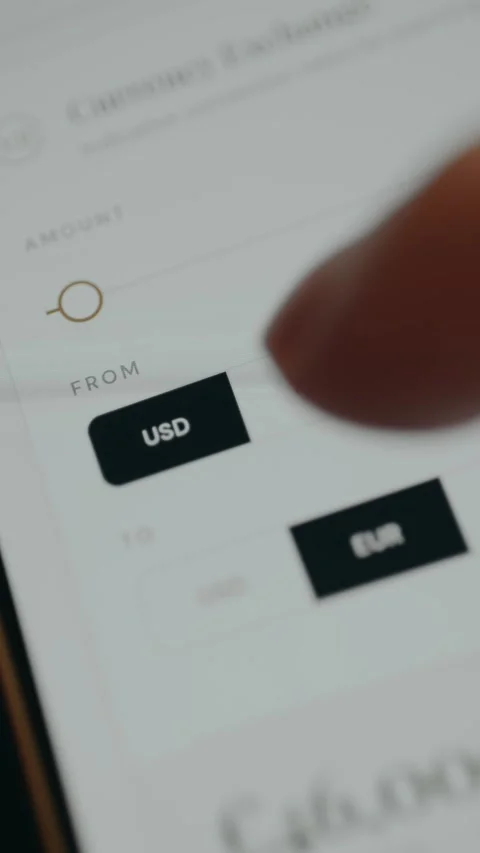 Currency conversion, person using options to select a FROM currency and TO Stock Footage 332488487