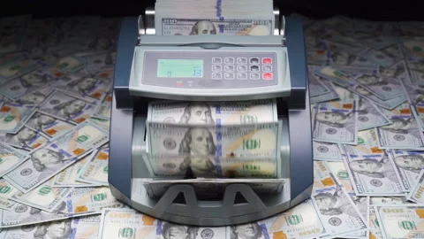 Currency counting machine stands on heap of hundred dollars. Cash bill counter Video stock 148541339