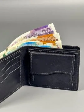 Currency notes in a black wallet ready for exchange in the UK Stock Photos
