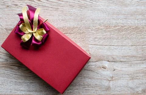 The current box has red and gold ribbons placed on an old wooden table with.. Stock Photos
