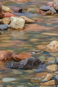 The current of a river flowing over rocks and stones 스톡 사진