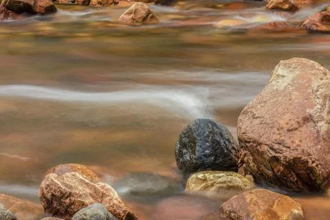 The current of a river flowing over rocks and stones Stock Photos