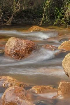 The current of a river flowing over rocks and stones Stock Photos
