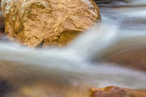 The current of a river flowing over rocks and stones Stock Photos