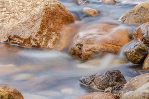 The current of a river flowing over rocks and stones Fotos de archivo