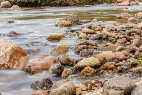 The current of a river flowing over rocks and stones Stock-Fotos