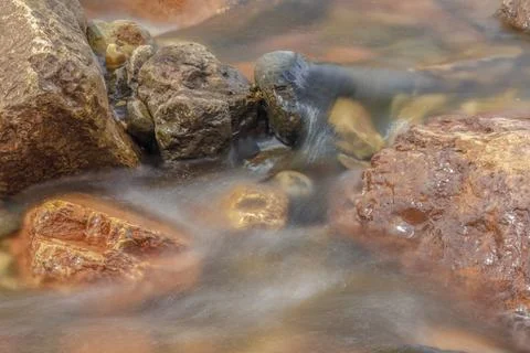 The current of a river flowing over rocks and stones Stock Photos