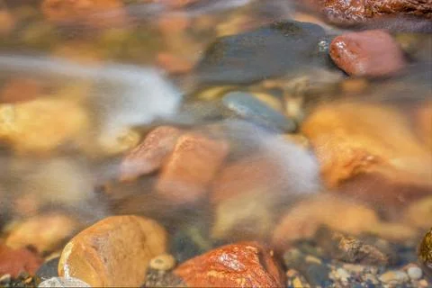 The current of a river flowing over rocks and stones Stockfoto's