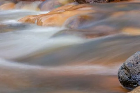 The current of a river flowing over rocks and stones Stock Photos