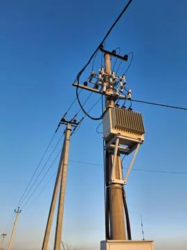 Current transformer and high voltage power lines on blue background Foto stock
