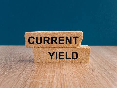 Current Yield text concept on brick blocks. Beautiful wooden table Stock Photos