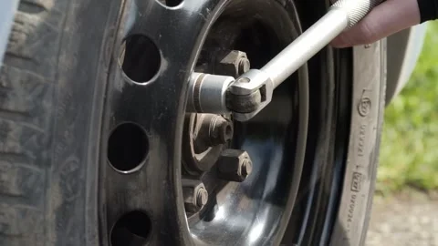 Currently changing a tire with a ratchet tool, adjusting all components as Stock Footage 309695920