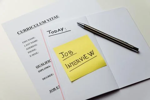 Curriculum vitae and notebook with text "today job interview".  Stock Photos