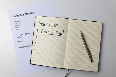 Curriculum vitae and notebook with text "priorities, find a job".  Stock Photos