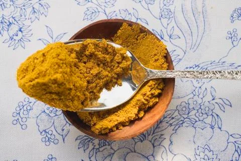 Curry powder in bowl and on spoon Stock Photos