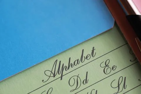 Cursive Alphabet Handwriting Practice Sheet with Pen on Colorful Background Stock Photos