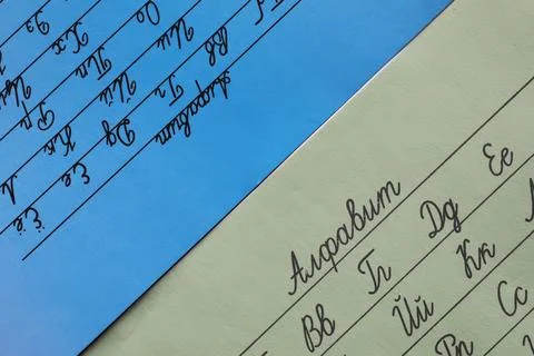 Cursive Writing Practice Sheets in Different Languages on Colored Paper Stock Photos