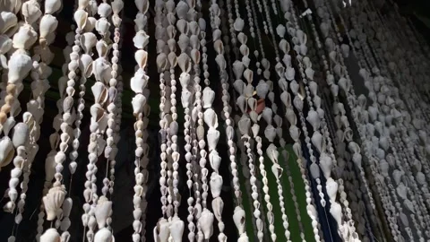 Curtain made from strings of seashells and sea snail shells Stockbeeldmateriaal 346837875