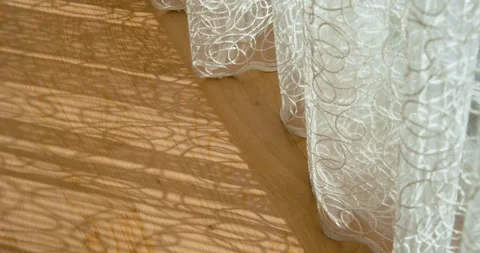 Curtains create a beautiful pattern on the wooden floor due to the sun. filmed Stock Footage 300979377