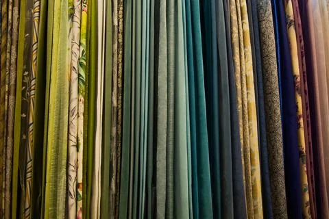 Curtains of different colors and patterns for the room hang horizontally. Stock Photos