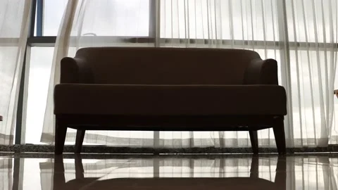 The curtains flutter in the wind from an open window behind the couch 動画素材 173116009