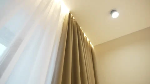Curtains hang from hidden cornice with soft lighting Vídeo Stock 318736026