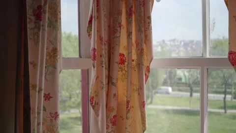 Curtains move at window with view of park and bus Stock Footage 335855523