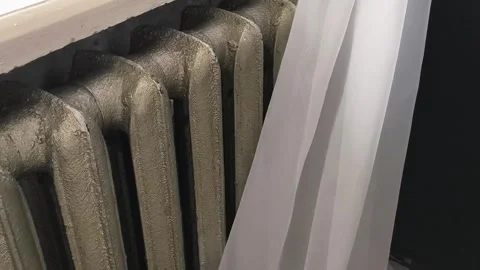 The curtains open and the old heating radiator becomes visible. Heating in the Stock Footage 325290520