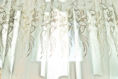 Curtains with a pattern in the hall illuminated by sunshine Foto stock