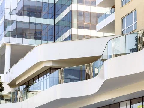Curved architectural elements connect various sections of the building. Glass Stock Photos