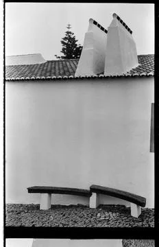 Curved Bench Beneath Whitewashed Walls and Chimneys Stock Photos