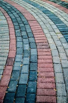 Curved brick pavement features red, gray, and blue bricks, creating a textu.. Foto stock