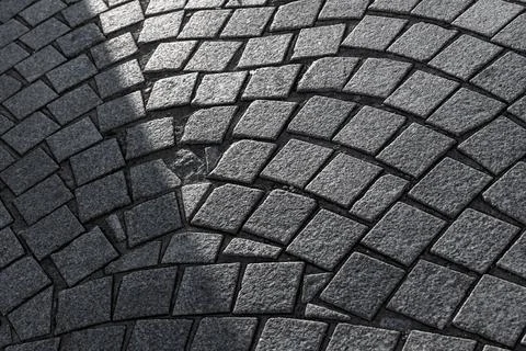 Curved cobblestone pavement forms repeating arced patterns Stock Photos