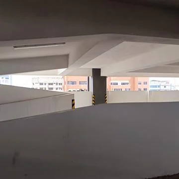 Curved concrete ramp inside multi-level parking garage Stock Photos